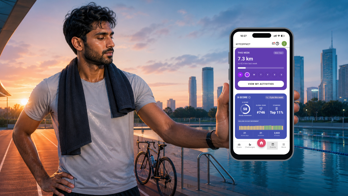 Athlete beside a running track, bicycle and pool holding the live Xfitconnect X-Score screen